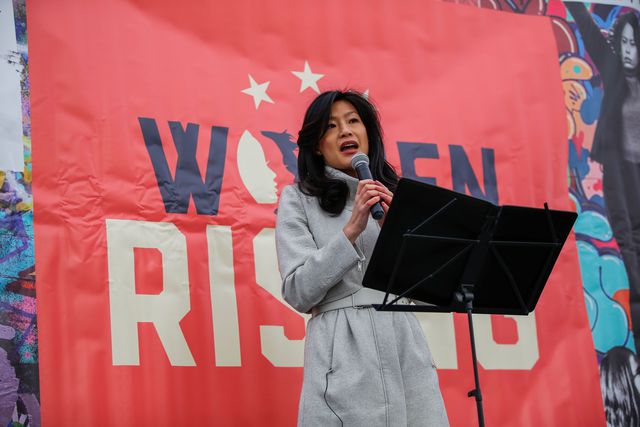 Evelyn Yang stands on a stage and speaks at the Women's March in NYC, January 18, 2020